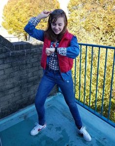 a girl is posing for the camera with her hands behind her head