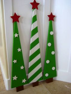 two wooden christmas trees with red and white stars on them