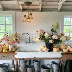 a kitchen filled with lots of buckets and flowers