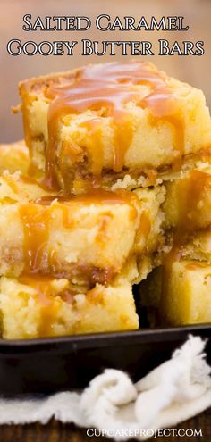 salted caramel gooey butter bars stacked on top of each other in a black plate