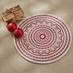 a red and white plate sitting on top of a table next to a wrapped present