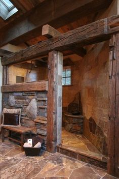 a stone fireplace in the corner of a room with exposed wood beams and brick flooring