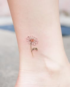 a small flower on the ankle is shown in this image, it appears to be pink