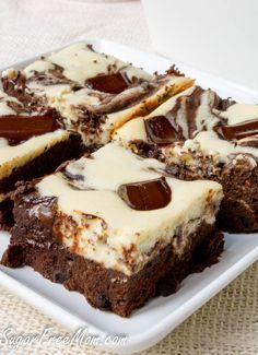 there are many brownies on the plate with white frosting and chocolate toppings