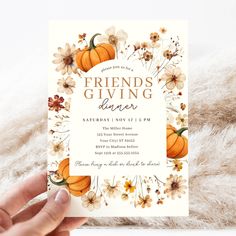 a person holding up a card with flowers and pumpkins on it that says friends giving dinner