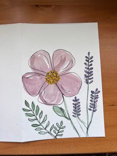 a drawing of a pink flower with green leaves and purple flowers in the middle on a white paper