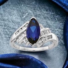 a blue and white ring sitting on top of a blue cloth covered table next to a bag