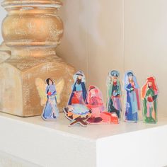 the nativity figurines are sitting on the shelf next to the candle holder