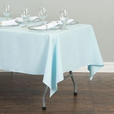 the table is set with glasses and plates on it, ready to be used as a centerpiece