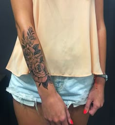 a woman with a rose tattoo on her left arm and right hand in the other