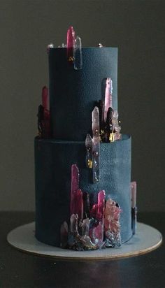 a three tiered cake with pink and blue icing on it's side