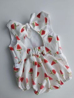 Introducing the Summer Breeze Baby Romper, a charming and practical choice for your little one's warm-weather wardrobe. Handmade with love from 100% cotton, this romper ensures both comfort and breathability. The playful watermelon print adds a touch of fun, while the tie-back and snap-front design make dressing and diaper changes easy. Available in sizes 0-3 months to 6-9 months, this romper is perfect for keeping your baby cool and stylish all summer long. Cute Summer Bubble Romper For Vacation, Cute Summer Bubble Romper For Beach, Playful Summer Playwear For Babies, Cute Summer Beach Bubble Romper, Cotton Bubble Romper For Beach, Cotton Fitted Bubble Romper For Playwear, Sweet Bubble Romper For Summer Playwear, Fitted Cotton Bubble Romper In Sweet Style, Cute Fitted Bubble Romper For Summer