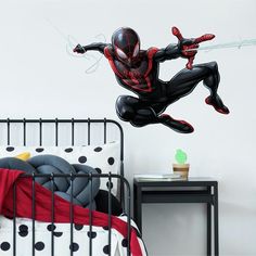 a bedroom with a spiderman wall decal on the wall