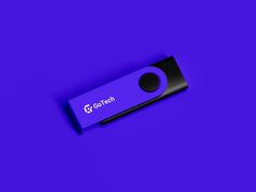 a purple and black usb stick sitting on top of a purple surface with the word go tech printed on it