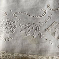 an embroidered tablecloth with white thread and beads