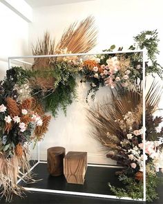 an arrangement of flowers and greenery on display