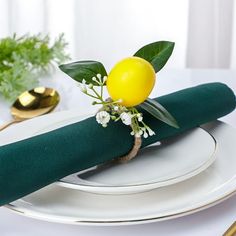 a place setting with green napkins and yellow lemon