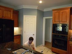 a man standing in a kitchen next to an oven