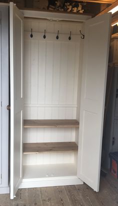 an empty white closet with shelves and hooks