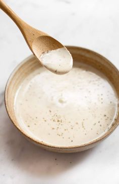 a wooden spoon in a bowl filled with cream