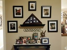 the wall is decorated with pictures, frames and an american flag hanging on it's mantle