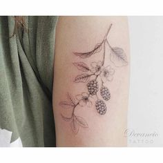 a woman's arm with flowers and leaves tattooed on the back of her arm