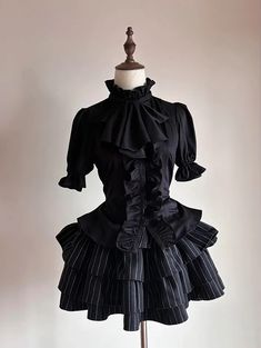 Step into the world of gothic elegance with our Black Jabot Collar Gothic Prince Style Ouji Short Sleeves Shirt. This exquisite piece features a refined jabot collar, exuding an air of aristocratic charm. The lace-up detail at the back not only adds a touch of classic sophistication but also ensures a perfect fit, accentuating your slim waist. This shirt combines the timeless allure of gothic fashion with the regal essence of prince-style attire.   	 		 			Size 			S 			M 			L 			XL 		 		 			Full Gothic Formal Tops With Ruffles, Black Fitted Top With Doll Collar, Fitted Gothic Blouse For Alternative Fashion, Elegant Black Top With Doll Collar, Gothic Fitted Blouse For Costume, Black Gothic Blouse For Formal Occasions, Fitted Gothic Blouse For Costume, Gothic Ruffle Blouse For Formal Occasions, Gothic Ruffled Blouse For Formal Occasions