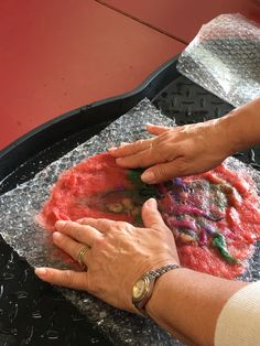 two hands touching something on top of a tray