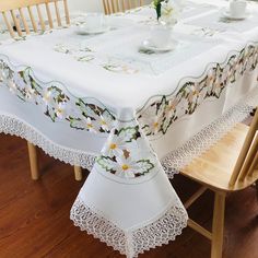 a white table cloth with daisies on it