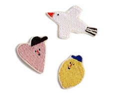 three embroidered appliques with different shapes and sizes, one in the shape of a bird