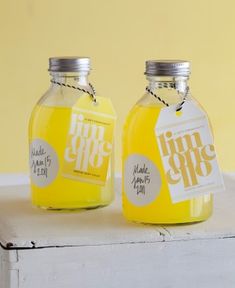 two jars with labels on them sitting next to each other