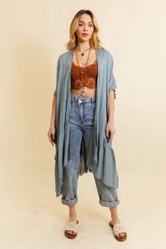 This bohemian-inspired kimono features a solid color palette and delicate ruffle edges, creating a timeless and effortlessly stylish look. Perfect for layering over any outfit, this kimono adds a touch of boho flair to your ensemble. Whether you're dressing up for a night out or looking for a stylish cover-up, our Solid Ruffle Edge Bohemian Kimono is the go-to choice for easy, breezy fashion. Our ethereal kimonos, offered in black, blue-gray, and ivory, embody effortless elegance. Each piece fea Bohemian Relaxed Fit Kimono For Daywear, Bohemian Spring Outerwear With Fringe, Relaxed Fit Outerwear With Frayed Hem For Summer, Flowy Wrap Kimono For Fall, Spring Fringe Long Sleeve Kimono, Fall Flowy Wrap Kimono, Spring Fringed Long Sleeve Kimono, Fall Rayon Open Front Kimono, Spring Long Sleeve Fringed Kimono