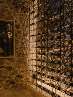 a stone wall with wine bottles on it and a window in the backround