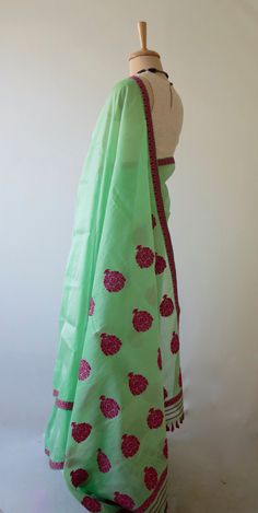 This is a genuine handloom sari from our looms in Assam , India .  The sari is made from mulberry silk and all the motifs are in acrylic.  The sari is sheer with a crisp hand and very light. It has mulberry silk in the warp and raw mulberry silk in the weft. The presence of raw mulberry silk makes it translucent and organza look .  These saris have a tendency to be slightly fluffy.  The Sari comes with blouse piece that has a plain body ( same as sari without the flowers ) and borders. But you c Pista Green Tussar Silk Dupatta In Traditional Drape, Pista Green Art Silk Handloom Traditional Wear, Pista Green Handloom Art Silk Traditional Wear, Pista Green Cotton Silk Dupatta For Festivals, Pista Green Art Silk Traditional Wear Handloom, Pista Green Chanderi Dupatta For Traditional Ceremonies, Pista Green Silk Handloom Traditional Wear, Traditional Pista Green Tissue Silk Blouse Piece, Pista Green Silk Traditional Wear With Handloom Detail