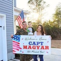 a man and woman holding a sign with a child