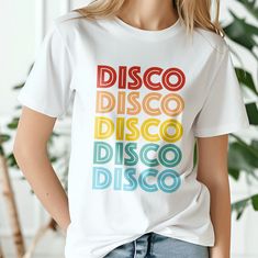 Unisex tshirt is ideal for 90s lovers, great gift idea for friends, neon multicolor print, "𝐃𝐈𝐒𝐂𝐎". These clothes are made of cotton. This t-shirt is suitable for any occasion. It can be a very good gift for someone who loves 70s/80s music. The classic fit and crew neck ensure a comfortable fit with a clear cut. Sent by a ❤ small business ❤ in Germany. Material: 100% cotton Weight: (180 g/m²) 𝐏𝐚𝐬𝐬𝐟𝐨𝐫𝐦: Easy Wash: Machine wash: cold (max. 30 oC); Chlorine-free: bleach as needed; Tumb Trendy Multicolor T-shirt With Text Print, Retro Multicolor Screen Print T-shirt, Retro Multicolor Print Summer T-shirt, White Retro Print T-shirt For Streetwear, Trendy Multicolor Pride T-shirt, Retro Rainbow T-shirt For Summer, Vintage Multicolor T-shirt With Letter Print, Multicolor Retro Tops With Letter Print, Disco Style Cotton Short Sleeve Tops