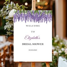 a welcome sign with purple flowers and greenery in the background for an elegant bridal shower