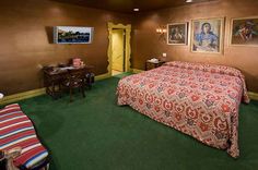 a bed room with a neatly made bed and pictures on the wall