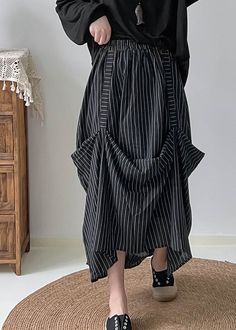 a woman standing on top of a rug wearing black and white striped skirt with ruffles