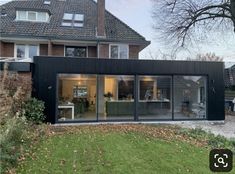 a black house with glass doors and windows