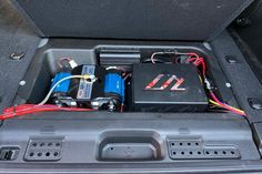 an open trunk with two batteries and wires in it