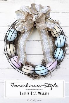 an easter egg wreath is hung on the side of a white door with a burluck bow