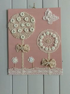 a pink card with buttons and lace on it