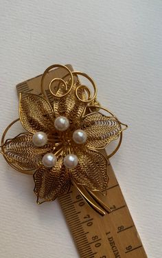 This listing is for the Midcentury Orchid Gold tone metal and faux pearl brooch that you see featured in photos. This pin is gold plated metal with assortment of white faux pearl accents. This pin/brooch is in nice used condition. Please take a look at photos, this is the actual brooch you will receive in the order. Please follow our shop link for more vintage! https://www.etsy.com/shop/CandilandArt Elegant Gold Flower Lapel Pin, Gold Flower Pins For Wedding, Gold Flower Brooch Pins, Gold Clip-on Costume Jewelry Brooch, Gold Clip-on Brooch For Wedding, Gold Clip-on Brooches For Wedding, Gold Costume Jewelry Pins For Wedding, Gold Orchid, Mannequin Art