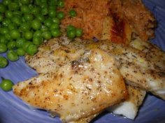 a blue plate topped with chicken, peas and rice