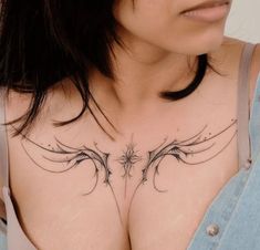 a woman's chest with an intricate tattoo design on her left shoulder and right breast