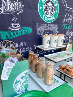 there are many starbucks drinks and snacks on the table at this coffee shop, including donuts