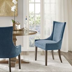 two blue chairs sitting in front of a table