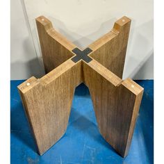 three pieces of wood sitting next to each other on a blue tablecloth covered floor