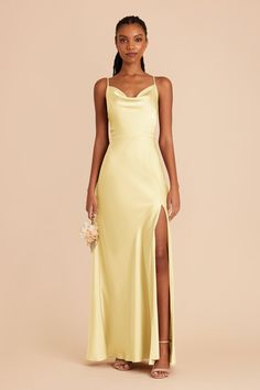 a woman wearing a yellow dress with a slit